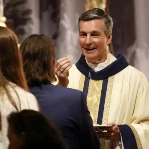 Marianist Father Peter H. Heiskell distributes Communion during his ordination to the priesthood Aug. 17, 2019, at the Marianist-run Chaminade High School in Mineola, N.Y. Father Heiskell, a 50-year-old Chaminade alumnus, was a Marianist religious brother for 30 years prior to his ordination. (CNS photo/Gregory A. Shemitz)