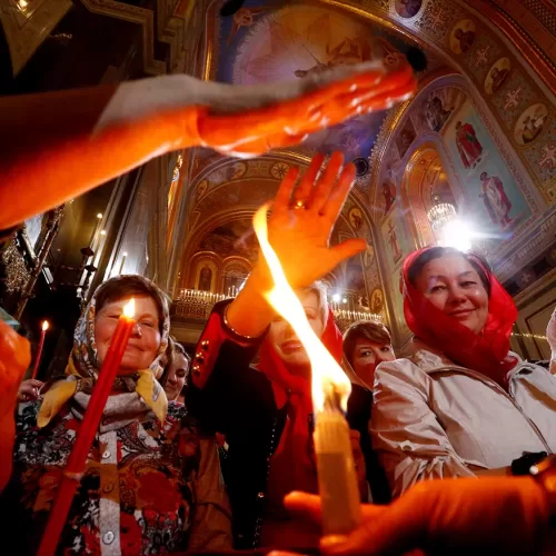 Worshippers reach out to touch candles with Holy Fire during an Orthodox Easter service at the Christ the Saviour Cathedral in Moscow, Russia, April 30, 2016. REUTERS/Sergei Karpukhin - RTX2CAWH